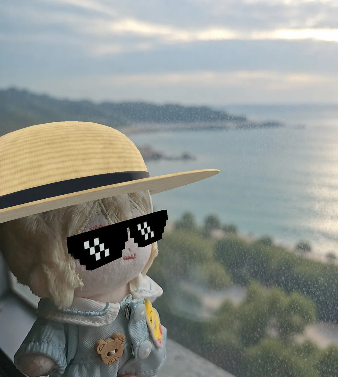 Blonde plush Lumi in a blue outfit by the sea, with an AR straw hat and pixel sunglasses added in nuirumi
